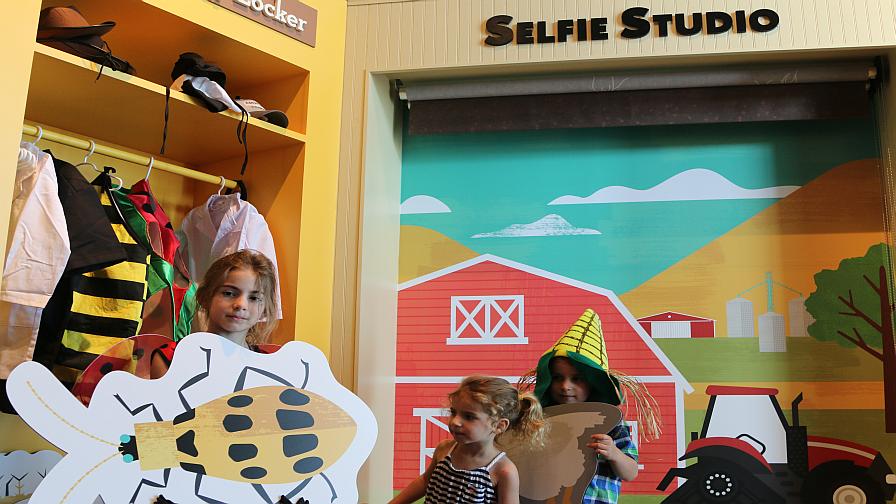 WinField Ag Technology Applications Lead Joel Wipperfurth's children play in the "Selfie Station" exhibit during the grand opening tour for the media. Wipperfurth was closely involved in the development of the WinField Crop Adventure.